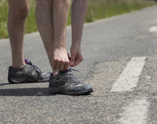 Man tying up running shoes