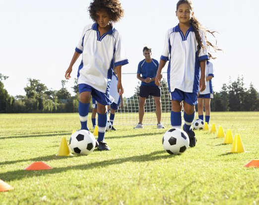 Young Girls and Coach At Football Practice