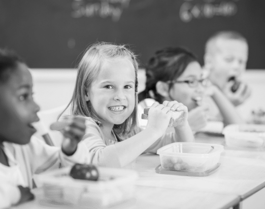 kids eating their packed lunch at a classroom desk