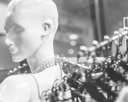 Mannequin in front of dresses
