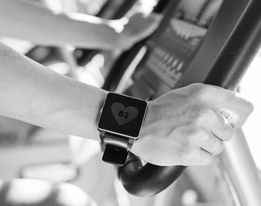 Man with a fitness tracker on an exercise bike