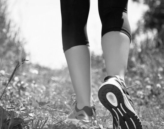 Woman in fitness clothes walking through a field
