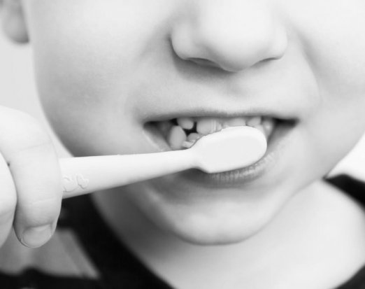 young boy's mouth with toothbrush