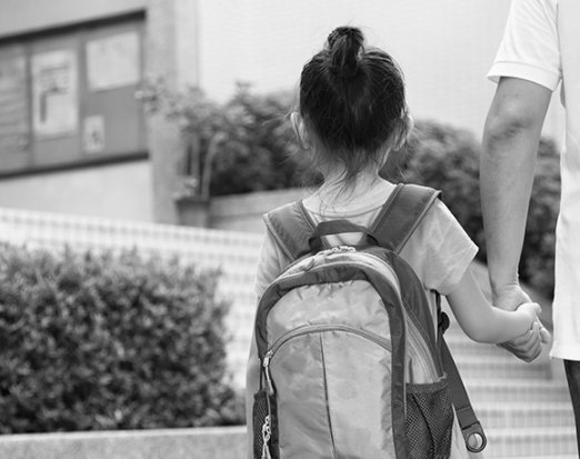 Girl with Pink Backpack Holding an Adult's Hand
