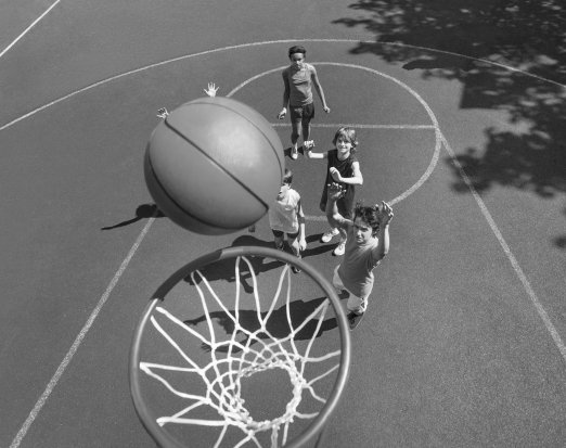 Young Children Shooting Basketball Hoops