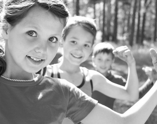 Three Children Flexing Their Biceps to Show Strength