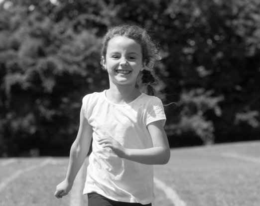 Young girl running and smiling outdoors