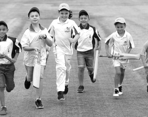 Six young boys running while holding cricket bats