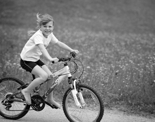 Young Girl Riding a Bicycle & Smiling