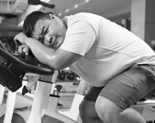 Overweight man on an exercise bike