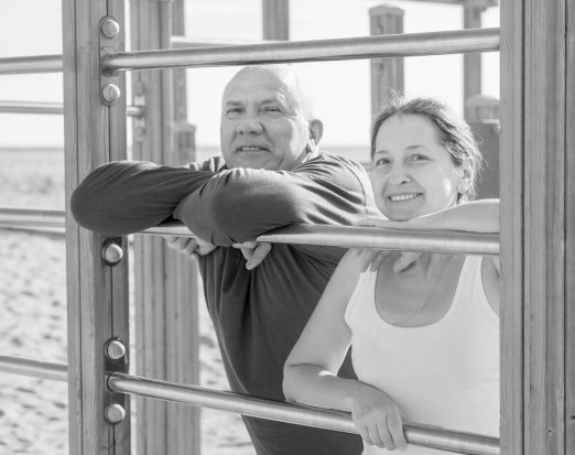 Mature couple training together on beach 