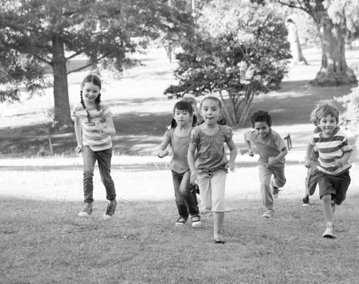 Children running up a grassy hill