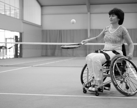 Woman in wheelchair playing tennis