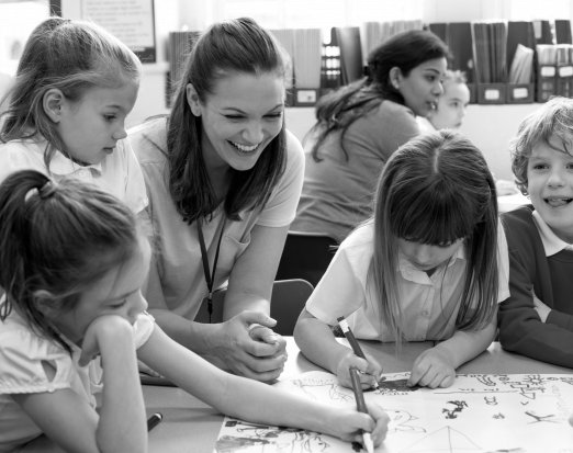 Smiling Teacher Looking at Her Pupils' Drawings