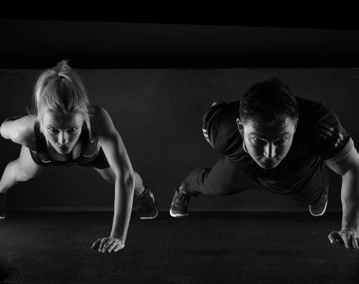 Two fitness models doing press ups