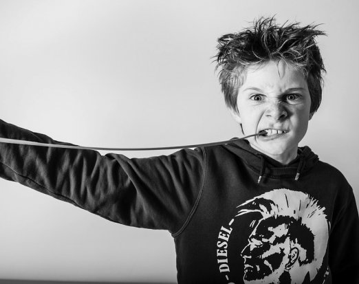 Young Boy Chewing Gum and Pulling a Fierce Face