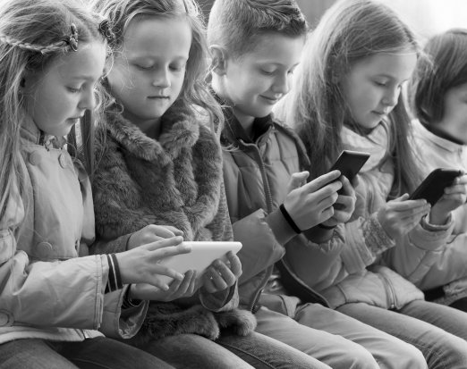 Young Children Staring At Their Mobile Phones 