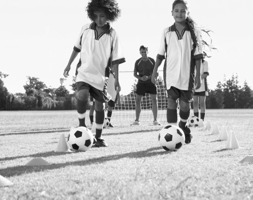 Young Girls and Coach At Football Practice